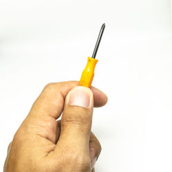 Close-up of hand holding paper against white background