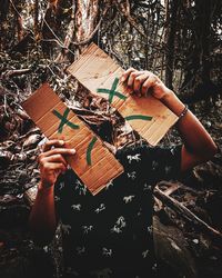 High angle view of woman reading book in forest