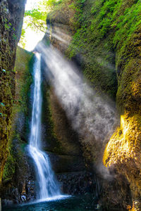 Scenic view of waterfall against sky