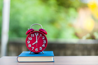 Close-up of alarm clock on book at home