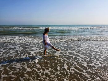 Full length of woman on beach against clear sky