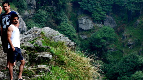 Tourists standing on rock in forest