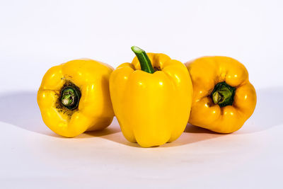 Close-up of yellow bell peppers on white background