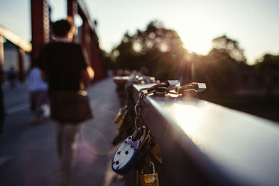 Woman walking by padlock on railing in city