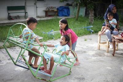 Rear view of two people sitting on floor