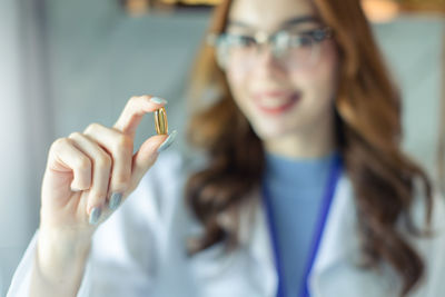 Woman holding fish oil capsule