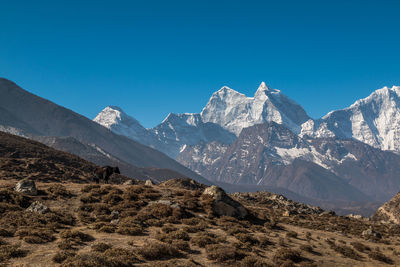 Scenic view of snowcapped mountains against clear blue sky