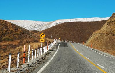 Road amidst mountains against clear sky