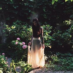 Woman standing on tree trunk