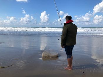 Full length rear view of man standing on beach