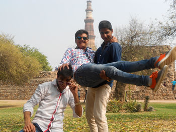 Young men standing against built structure