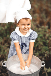 Girl dipping hands in laundry tub