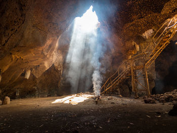 View of illuminated rock formation on land against sky