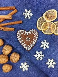 High angle view of gingerbread cookies with lemon and walnuts by cinnamon on table