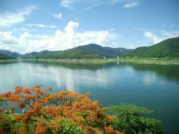 Scenic view of lake by mountains against sky