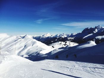 Scenic view of snowcapped mountains against blue sky