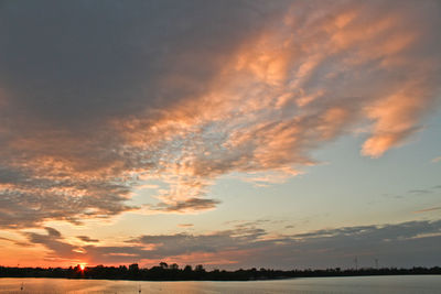 Scenic view of silhouette field against sky at sunset