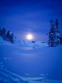 Scenic view of snow covered mountains against blue sky