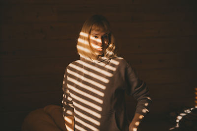 Portrait of woman standing against wall