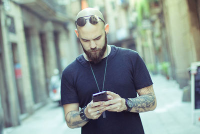 Young man using mobile phone in city