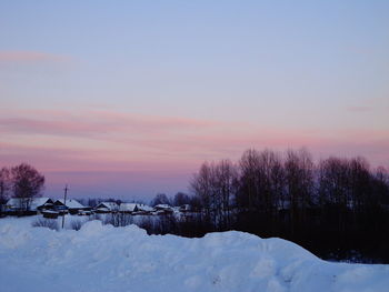 Scenic view of frozen landscape against sky at sunset