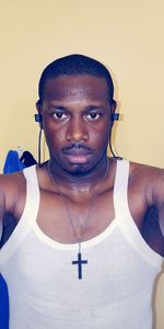 Portrait of young man standing against wall