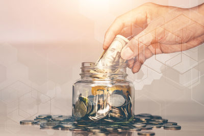 Hand holding glass jar on table
