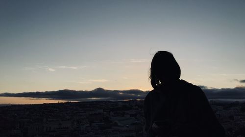 Rear view of silhouette man looking at sunset