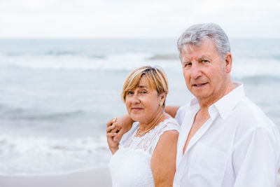 Portrait of senior couple standing at beach 