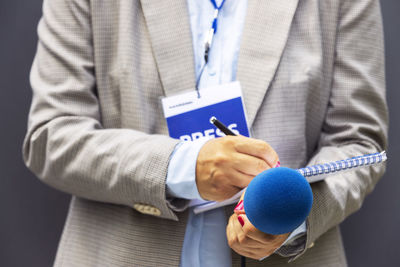 Journalist or news reporter at media event, holding microphone, writing notes. journalism concept.