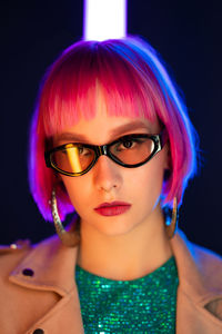 Portrait of woman standing against black background