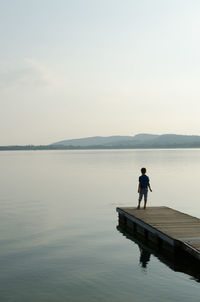 Man standing on lake against sky