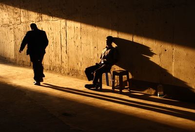 Man sitting by wall on chair