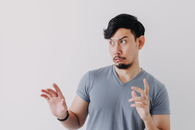 Portrait of young man standing against white background