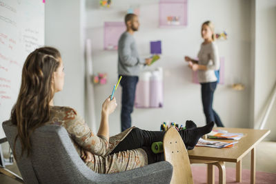 Businesswoman instructing coworkers in creative office