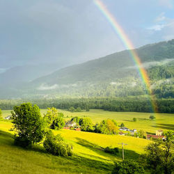 Scenic view of rainbow over landscape against sky