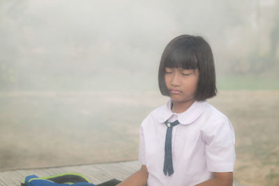 Girl meditating while sitting outdoors