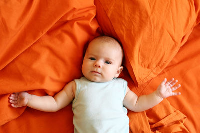 High angle portrait of cute baby girl lying on bed