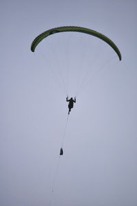 Low angle view of person paragliding against sky
