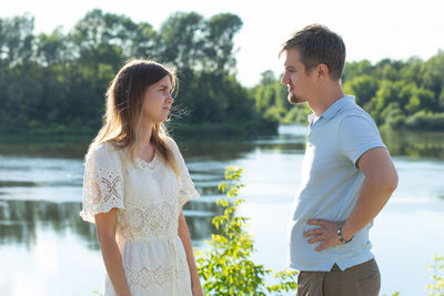 Young couple standing by lake