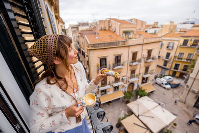Side view of young woman sitting on street
