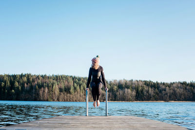 Woman about to jump into cold ice water whilst at the beach in sweden