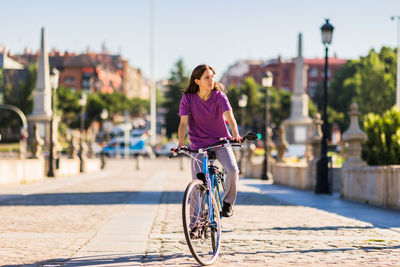 Rear view of man riding bicycle on street