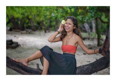 Portrait of smiling young woman sitting outdoors