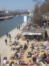 High angle view of people in city by sea against sky