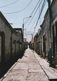 Road amidst buildings against clear sky