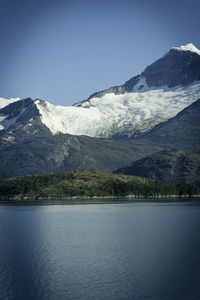 Scenic view of lake by snowcapped mountain against sky