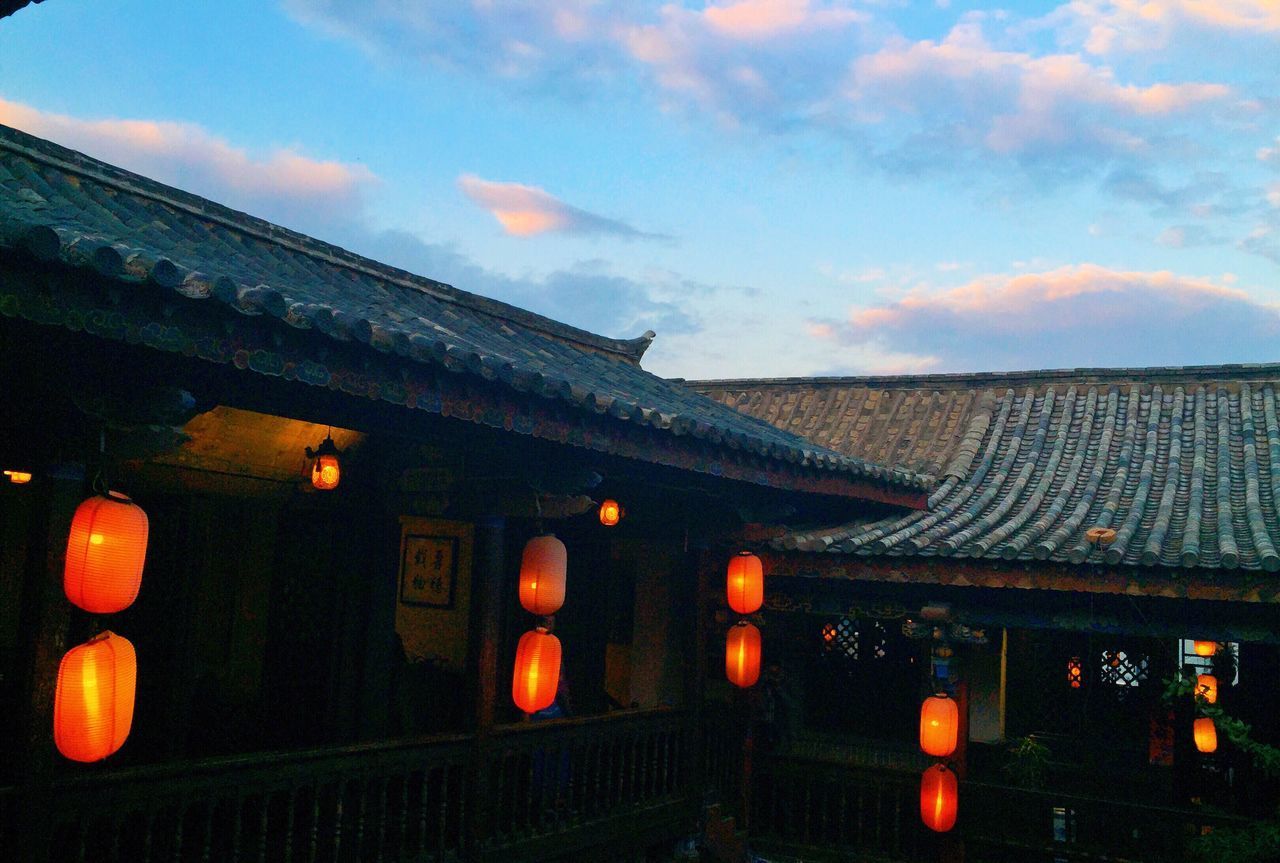 ILLUMINATED LANTERN BY BUILDING AGAINST SKY