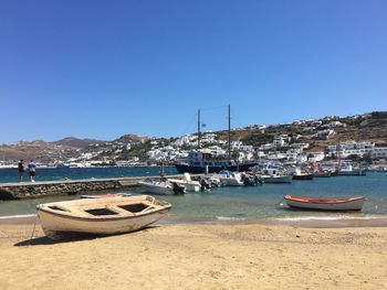 Boats in harbor against clear sky