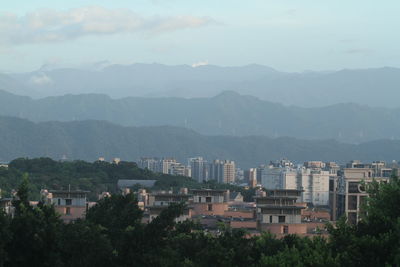 High angle view of townscape by mountains against sky